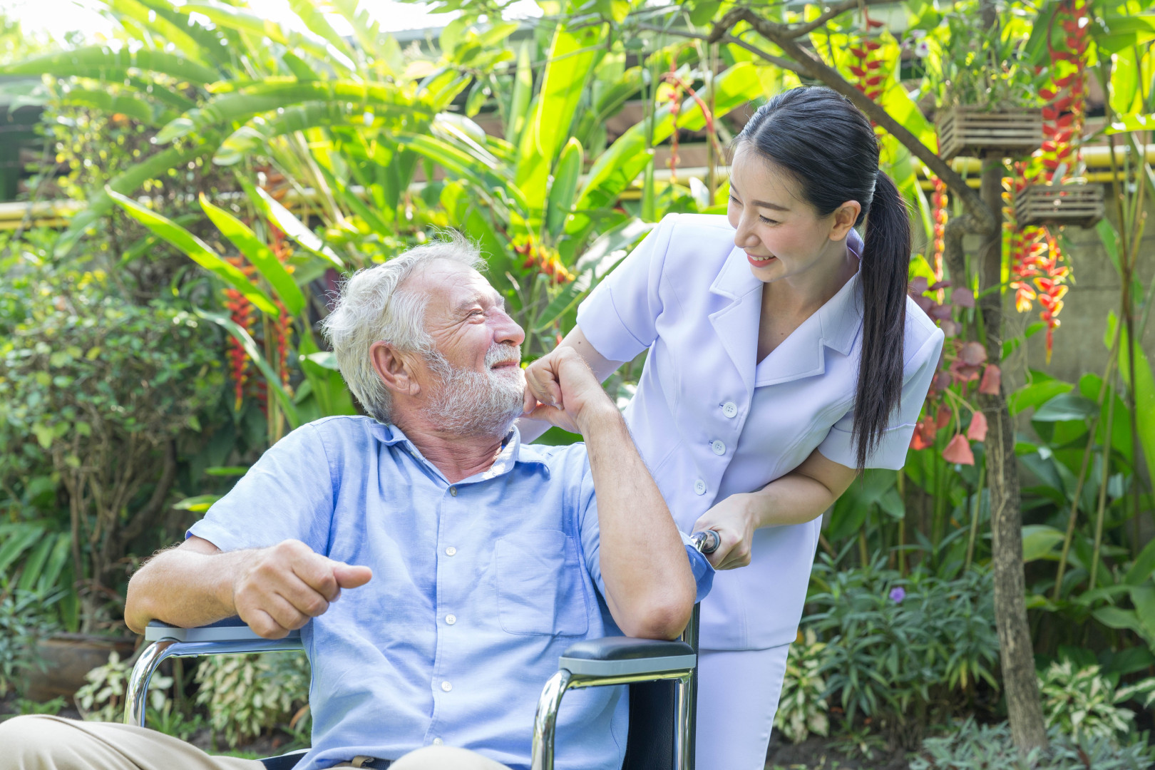 A woman taking care of a senior man in a wheelchair